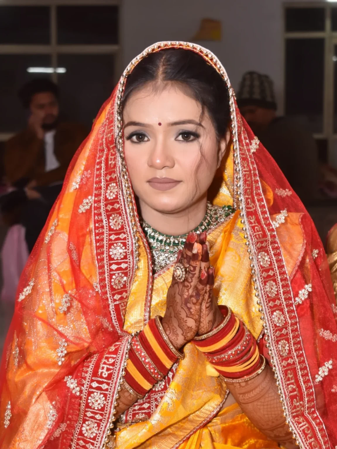 Bridal mehndi and namaste pose with traditional jewelry
